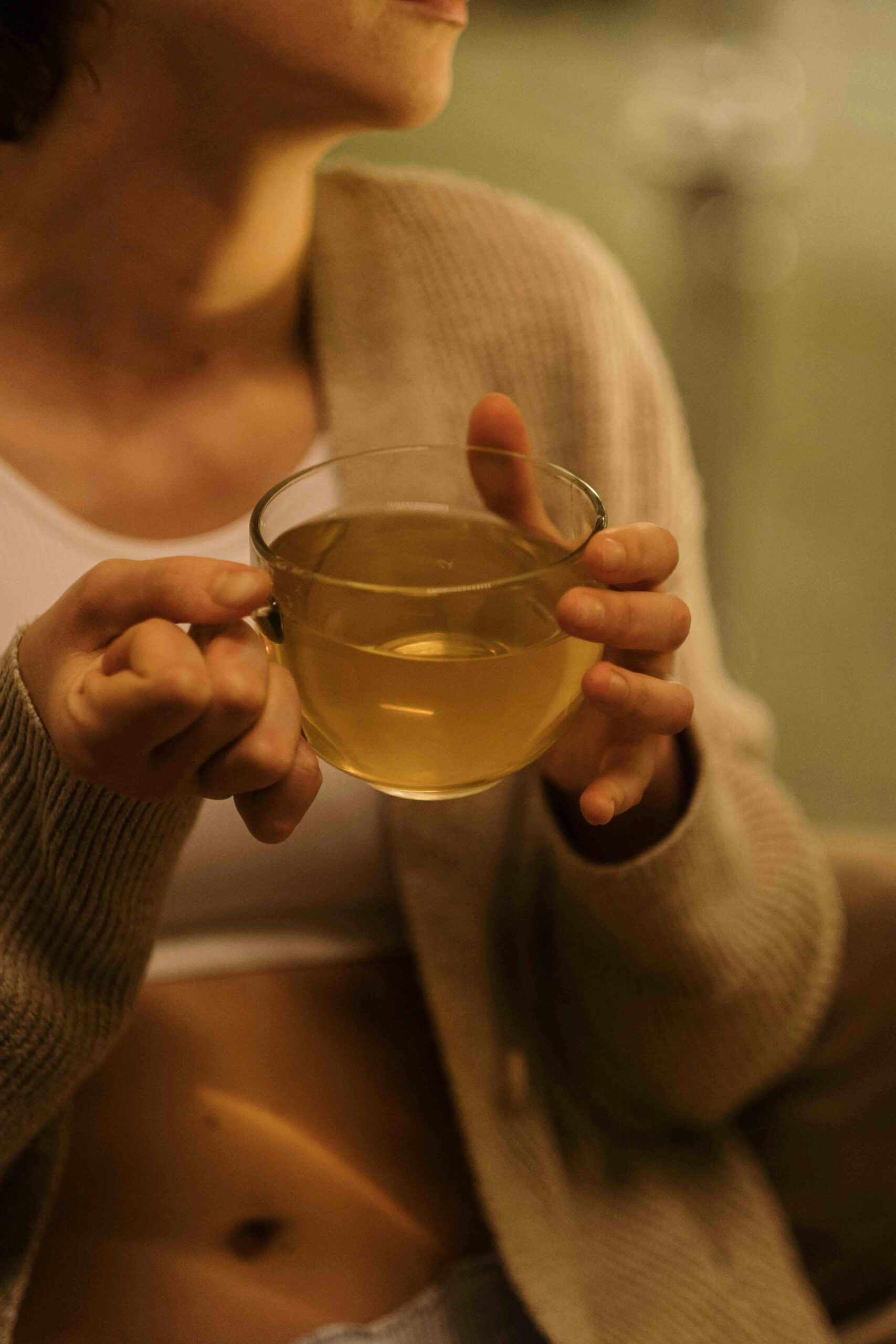 femme tenant une infusion chaude detox ayurvedique chez soi